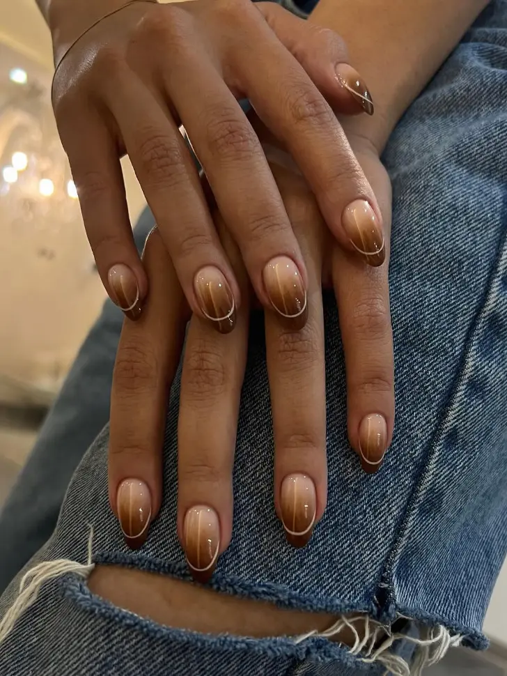 Коричневый маникюр омбре с золотыми линиями на овальных ногтях