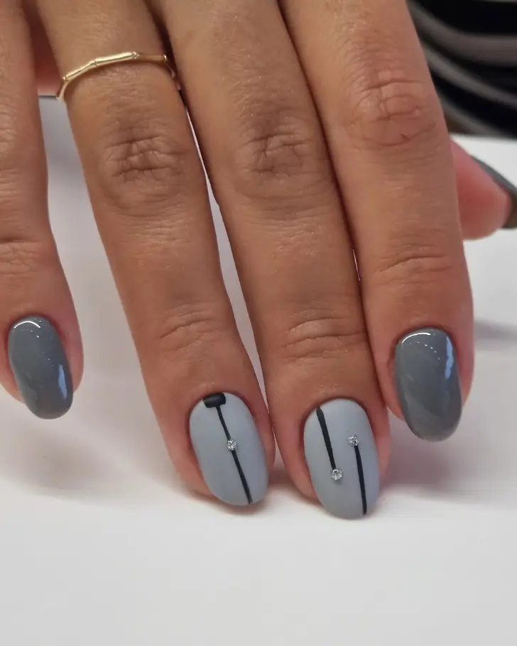 Серый маникюр с минималистичными линиями и стразами на овальных ногтях