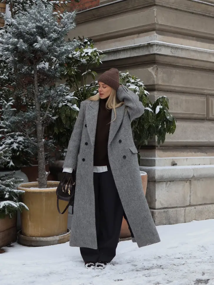 Девушка в черном джемпере и сером пальто