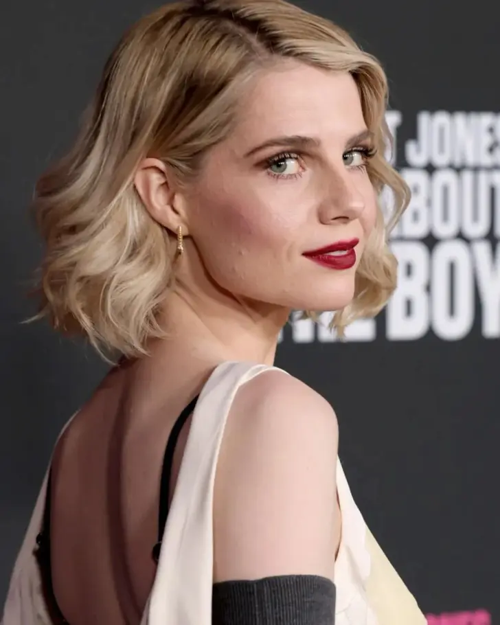 Элегантная стрижка боб с мягкими волнами и косой волноподобной челкой