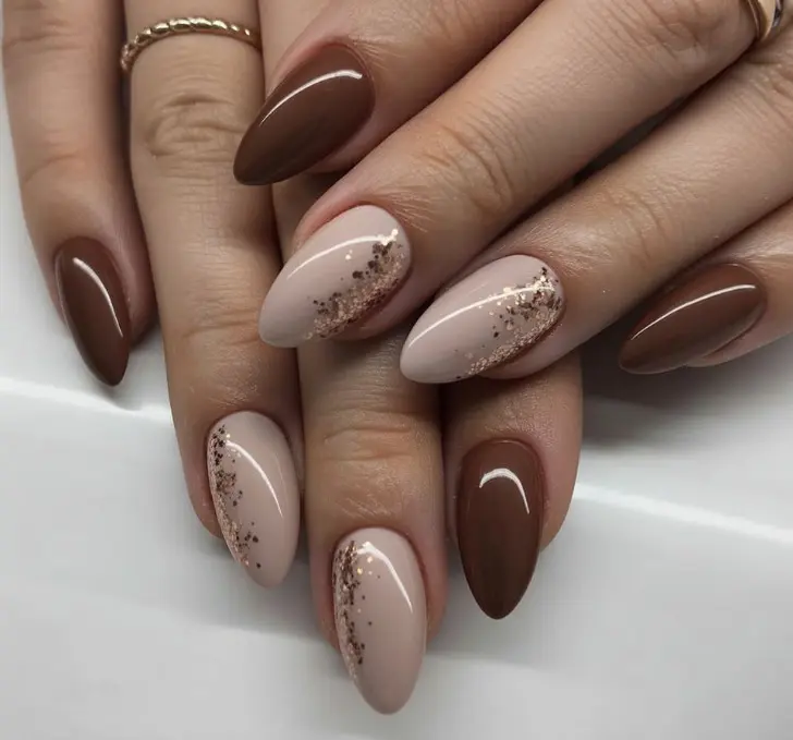 Коричневые миндальные ногти дополненные золотыми блестками