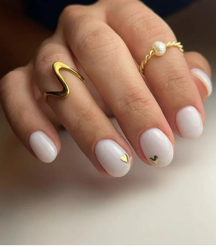 Короткий маникюр с молочной основой и золотыми микро сердечками