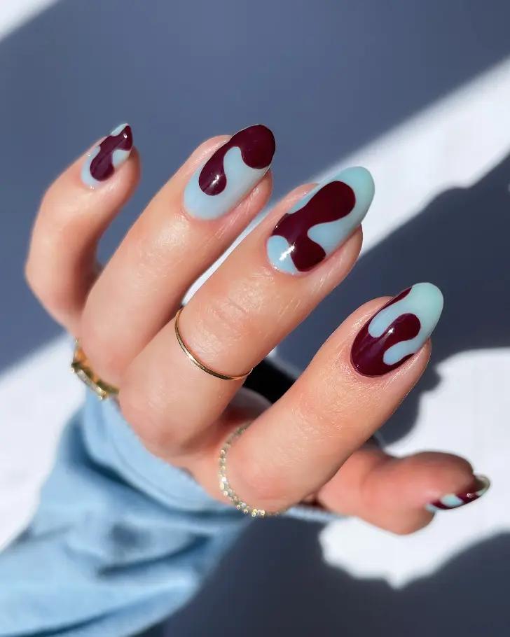 Овальные синие ногти с абстрактными коричневыми узорами