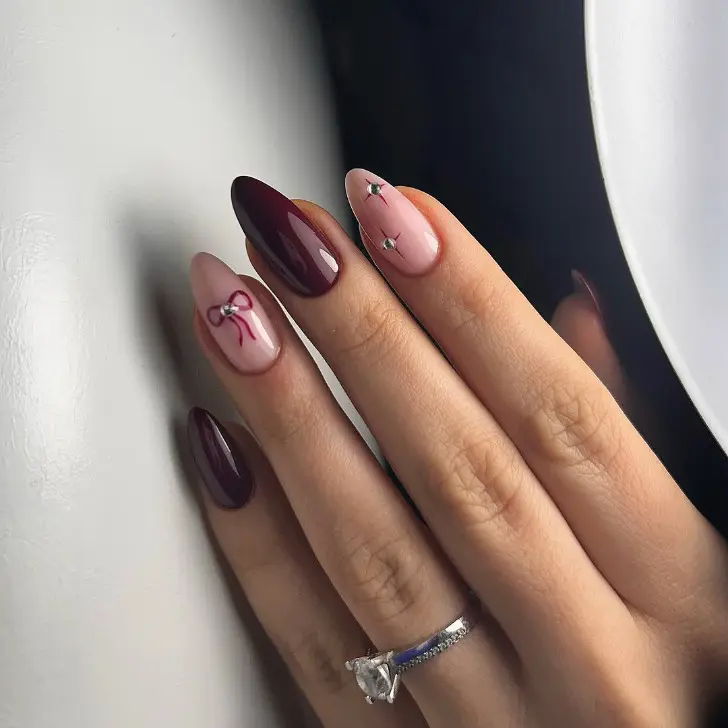 Бордовый женственный маникюр с бантом и звездами