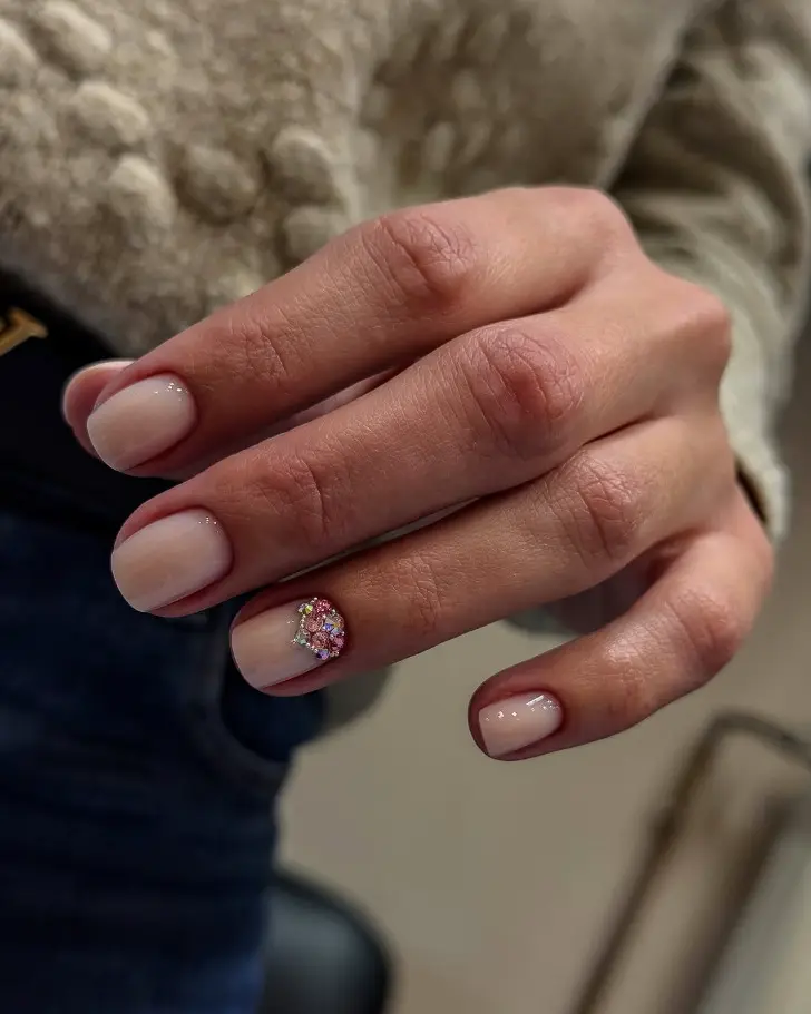 Короткий маникюр на февраль 2026 с акцентом в виде кристаллов на одном ногте