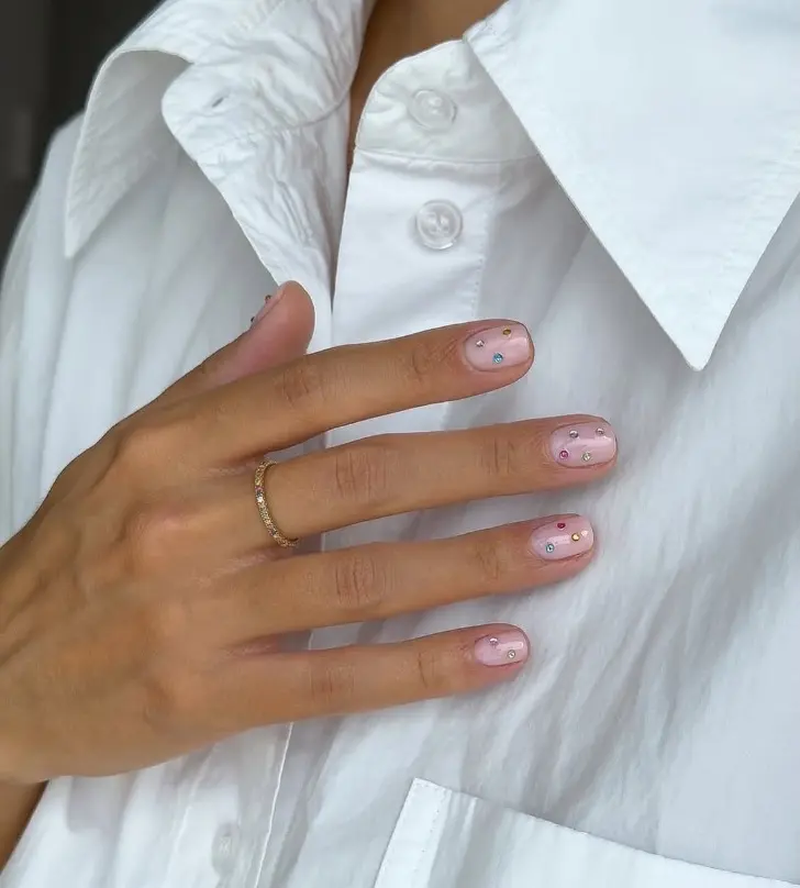 Короткий привлекательный маникюр с разноцветными кристаллами на чистой основе