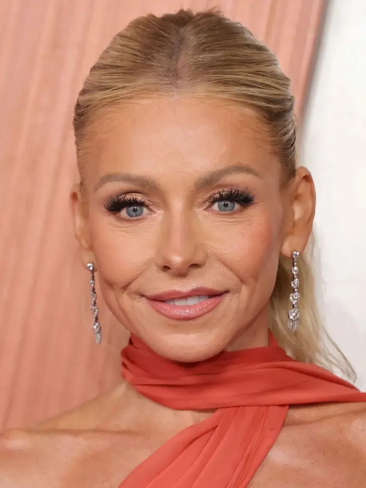 Лестная прическа с волосами убранными назад и низким хвостом