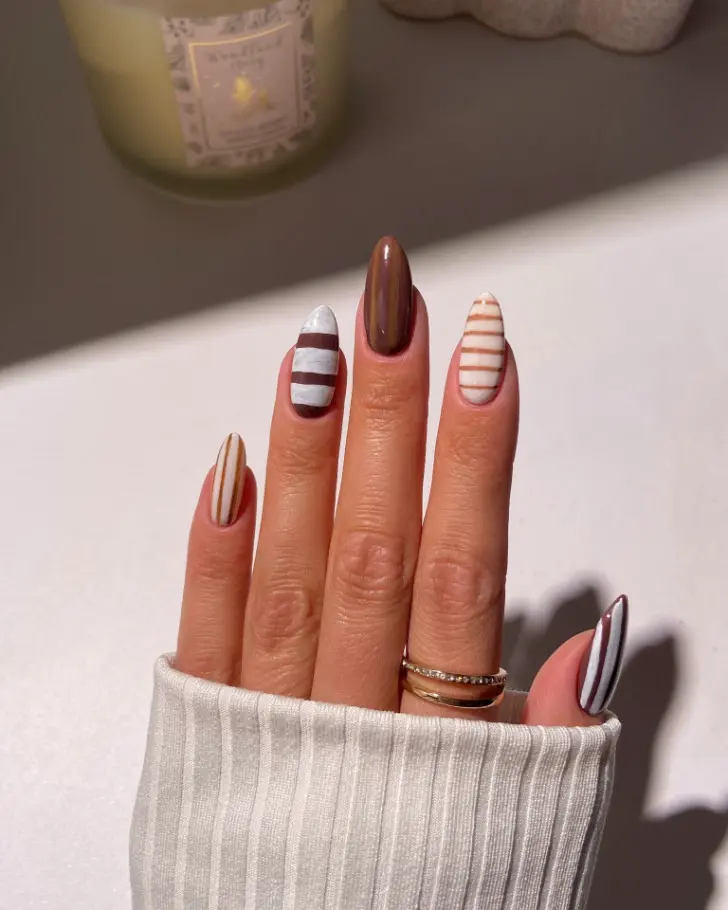 Маникюр в котором объединены мраморная основа с бежевой и украшены коричневыми полосами
