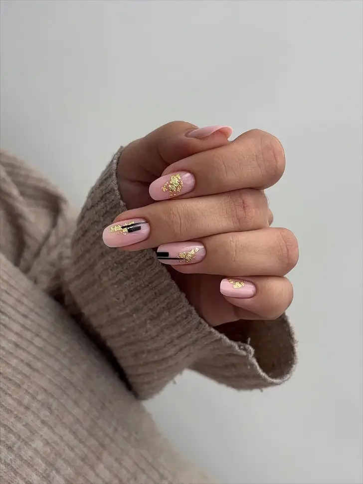 Овальный маникюр на февраль 2026 с золотой фольгой и черными узорами
