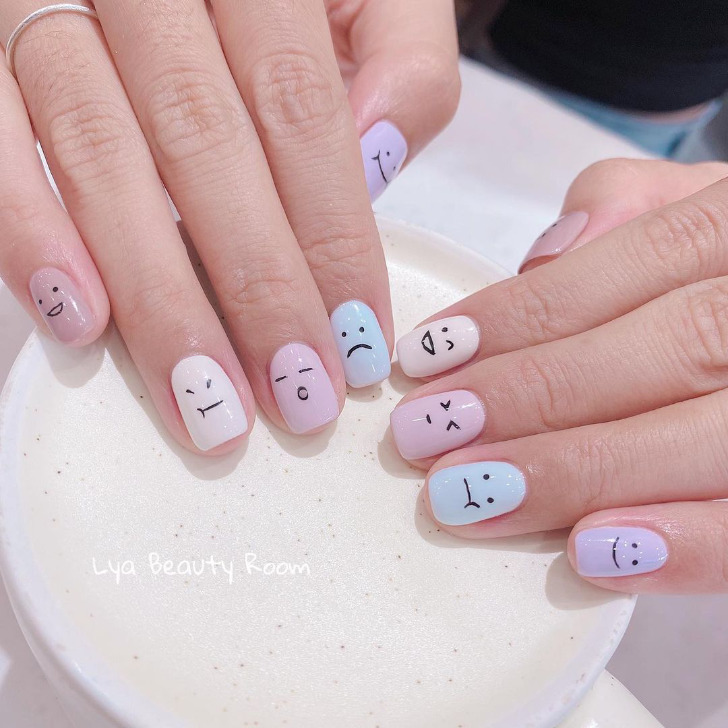 Пастельный маникюр с рисунками различных смайлов