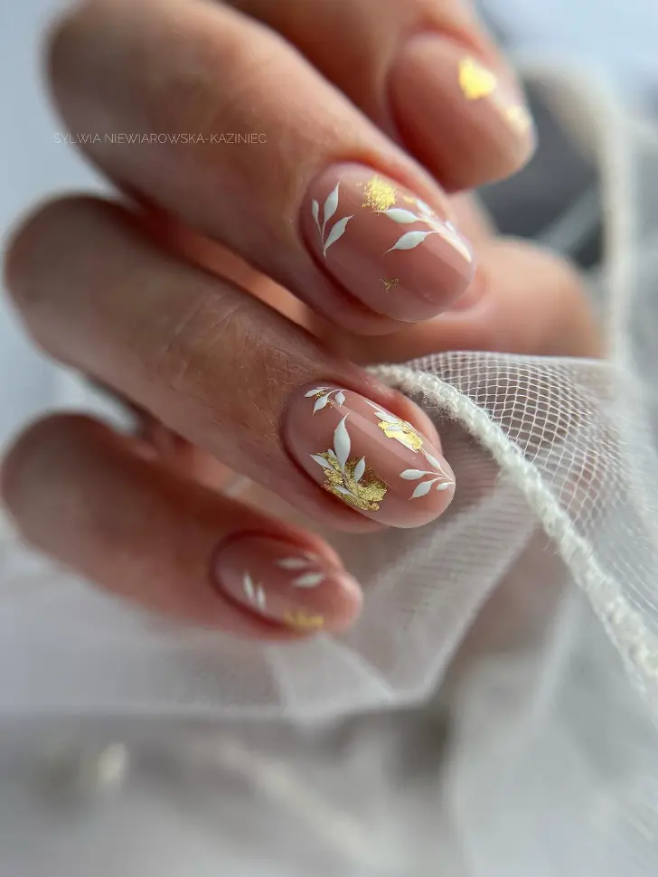 Женственный овальный маникюр с белыми цветами и золотой фольгой