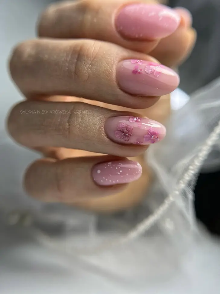 Женственный овальный маникюр с весенними цветами и белым снегом