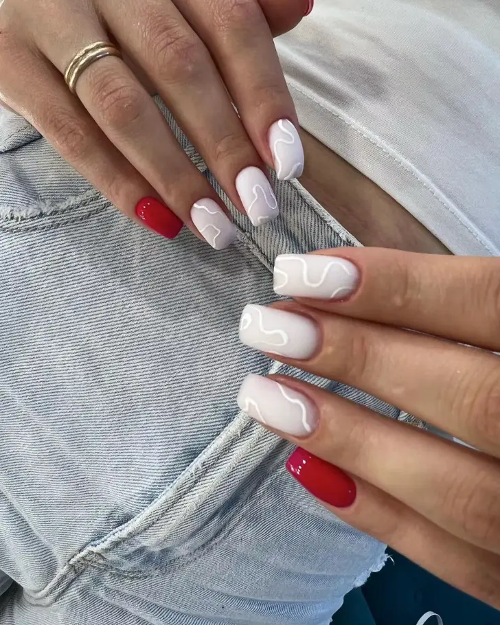 Белый маникюр с изогнутыми линиями и красными мизинцами