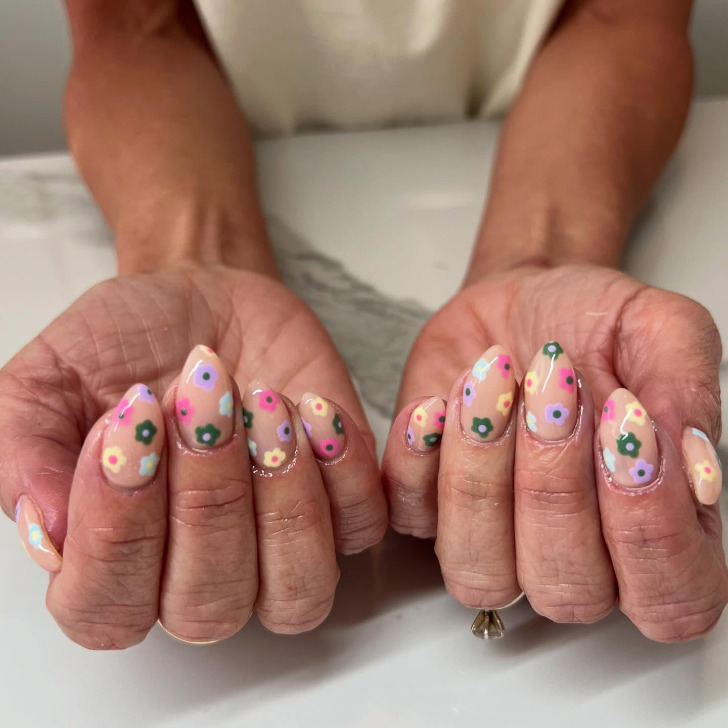Бежевый весенний маникюр с разноцветными ромашками разного цвета
