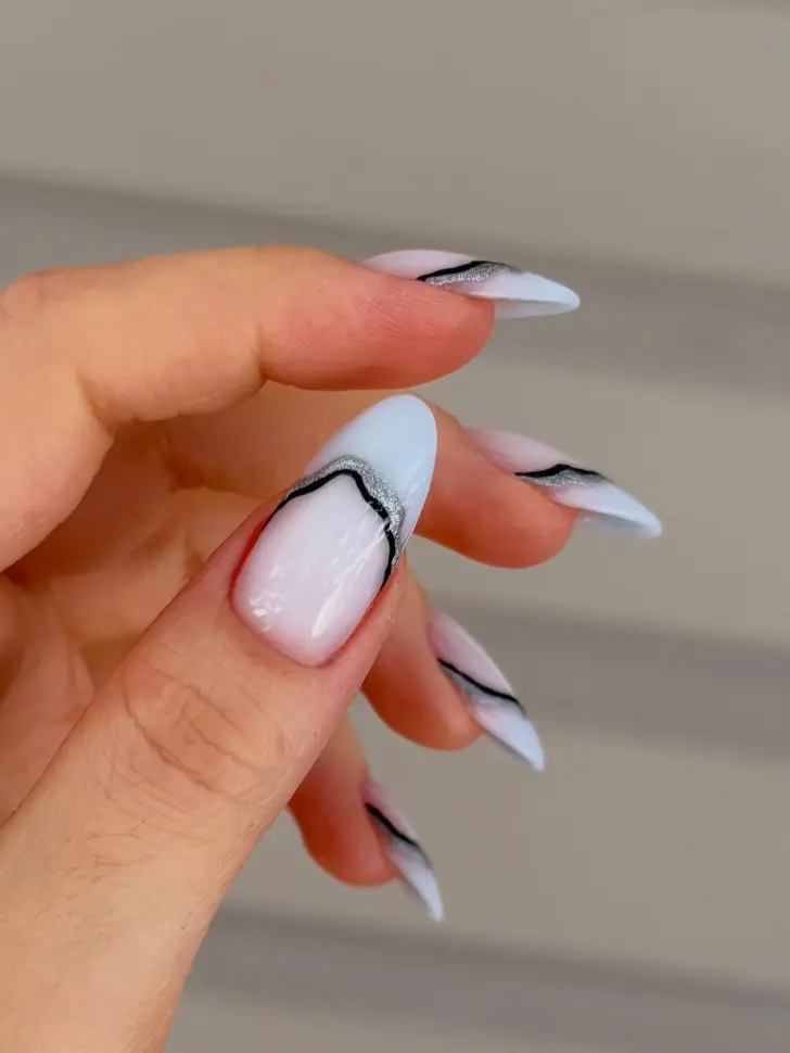 Молочный маникюр подчеркивающий красоту рук с серебряной и черной волнами