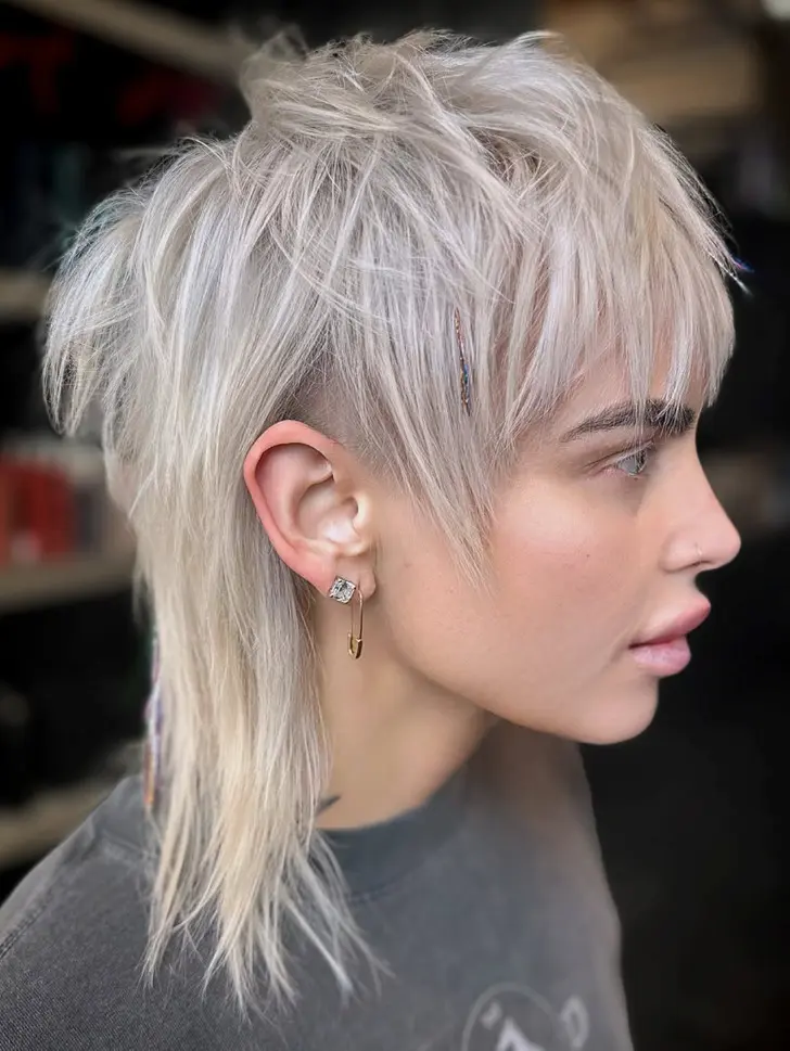 Смелая стрижка шегги с французской челкой и платиновыми волосами до плеч