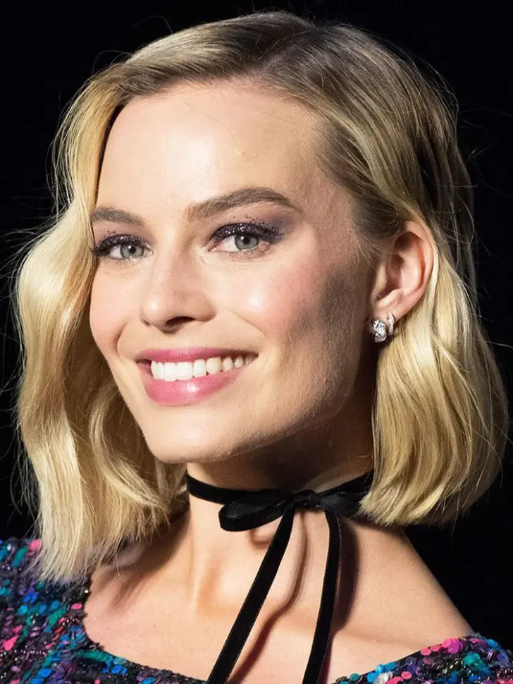 Стрижка на блонд волосах ниспадающих волной на плечи