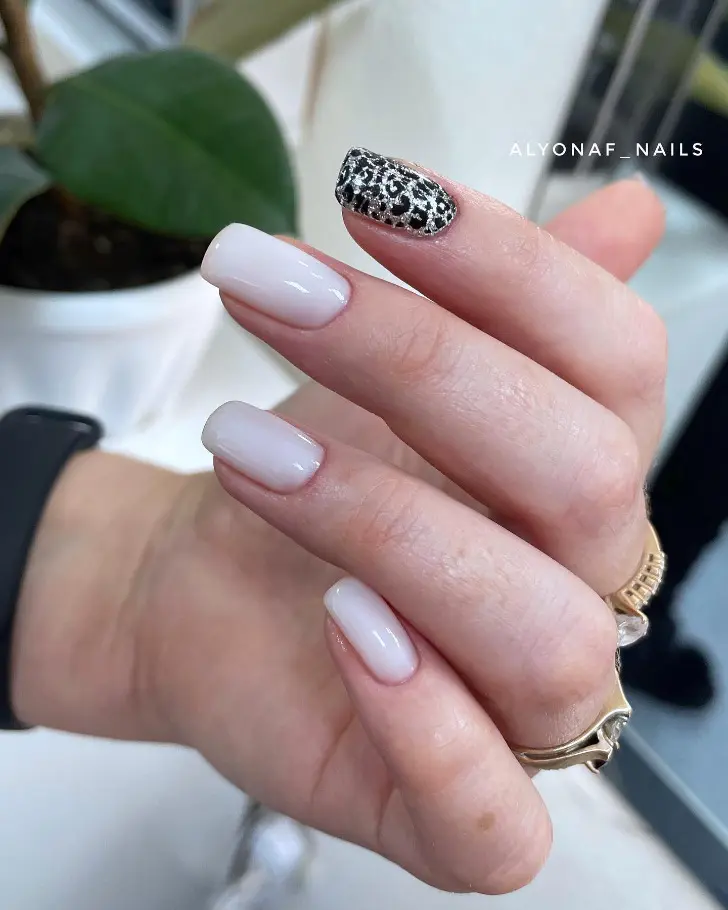 Светлый маникюр с акцентным серебряным ногтем с черным принтом леопарда