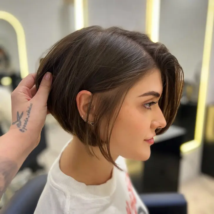 Асимметричная короткая стрижка с волосами убранными за ухо