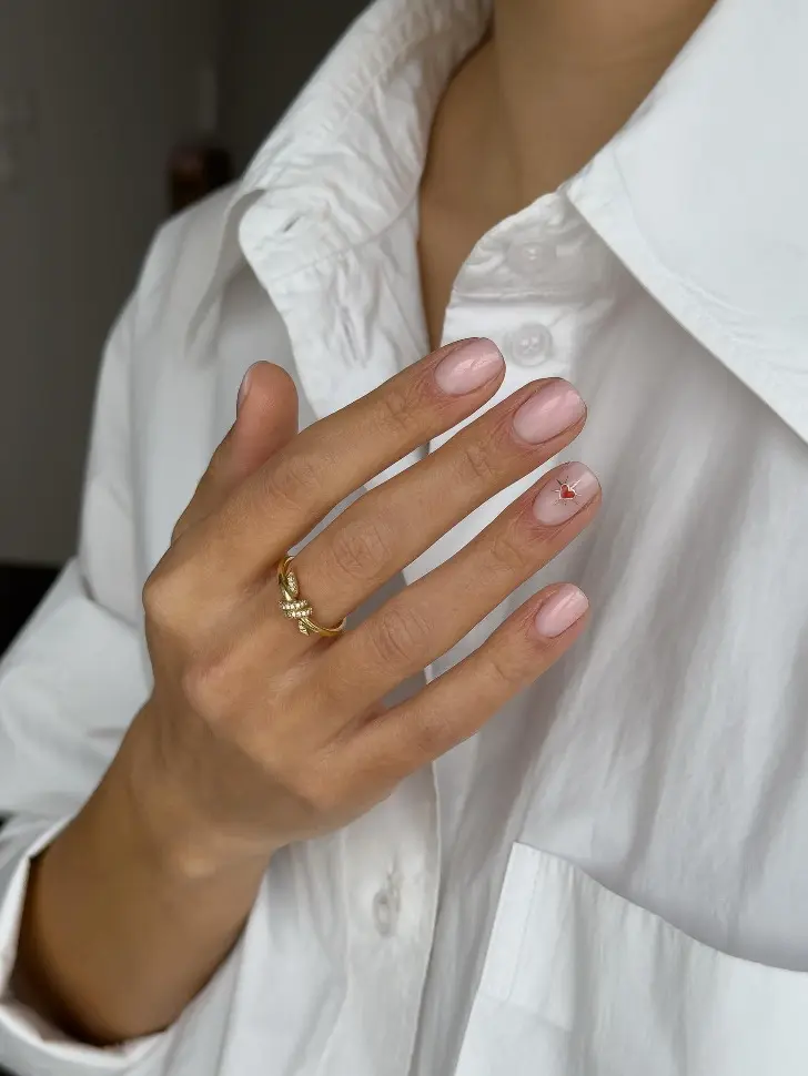 Дорогой чистый маникюр с красным сердцем в свете золота