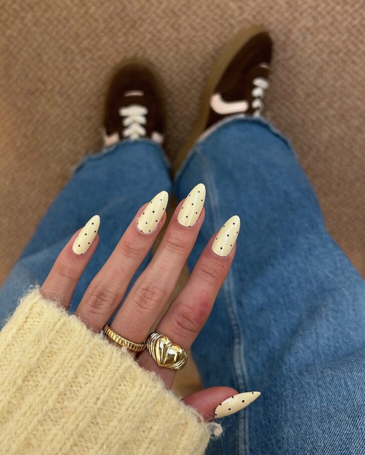 Маникюр с бледно желтой основой и черным горошком для стильных дам