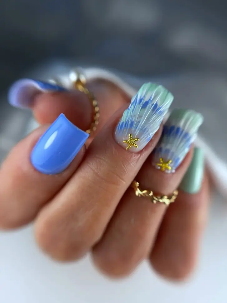 Маникюр в стиле гавайской юбки и с золотой звездой выглядит незабываемо