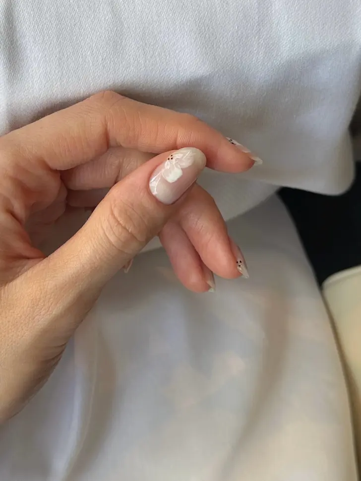 Овальный маникюр с бежевыми цветами для изящных леди