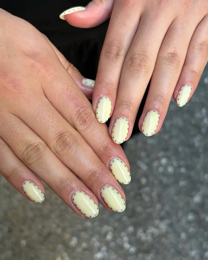 Овальный масляно желтый маникюр с серебряными точками по периметру