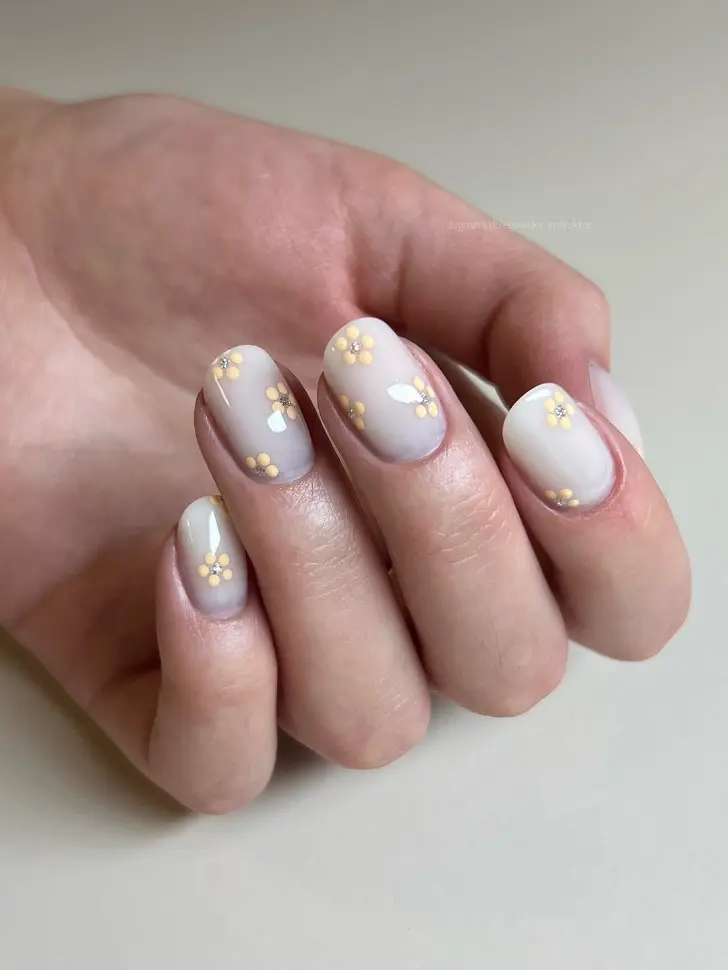 Овальный молочный маникюр с масляно желтыми ромашками