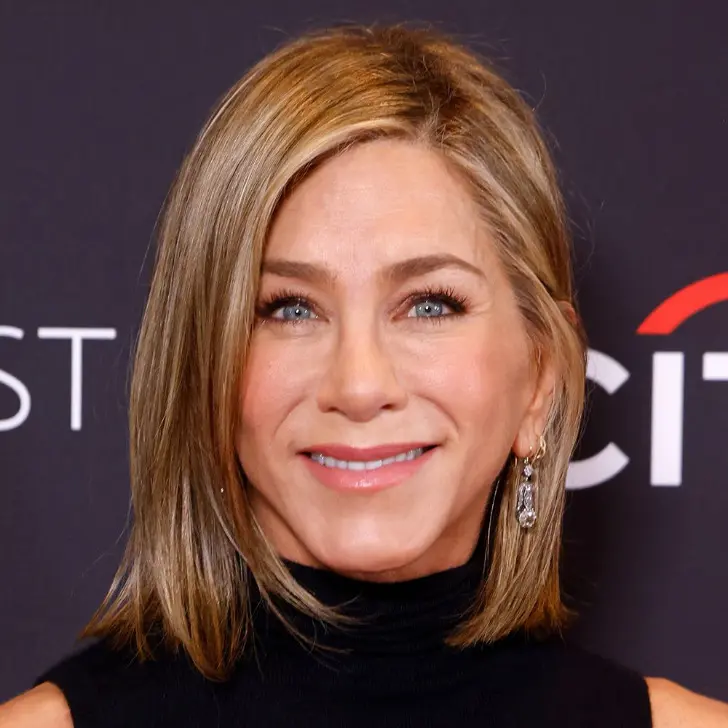 Прическа со светлыми волосами длиною до плеч боковым пробором и прядями обрамляющими лицо